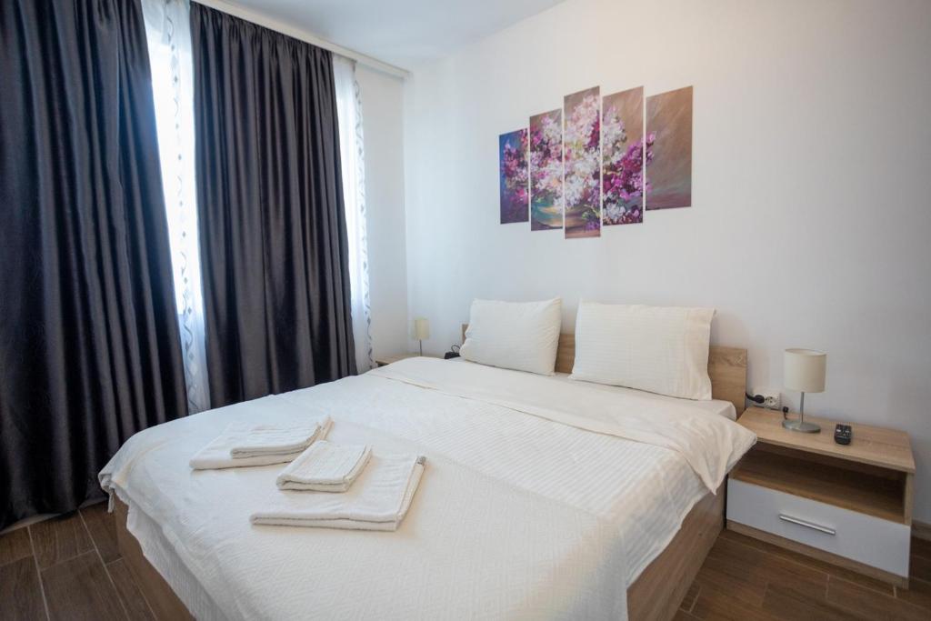 索非亚Karastoyanovi's apartment 2的卧室配有白色的床和2条毛巾