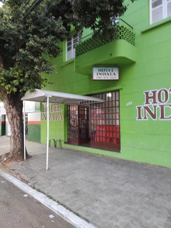 瓦拉达里斯州长市Hotel Indaiá的前面有标志的绿色建筑
