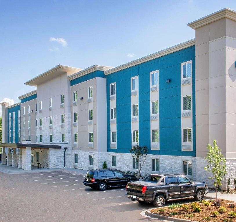 奥兰多Extended Stay America Select Suites - Orlando - Kissimmee的停车场内停放汽车的大型建筑