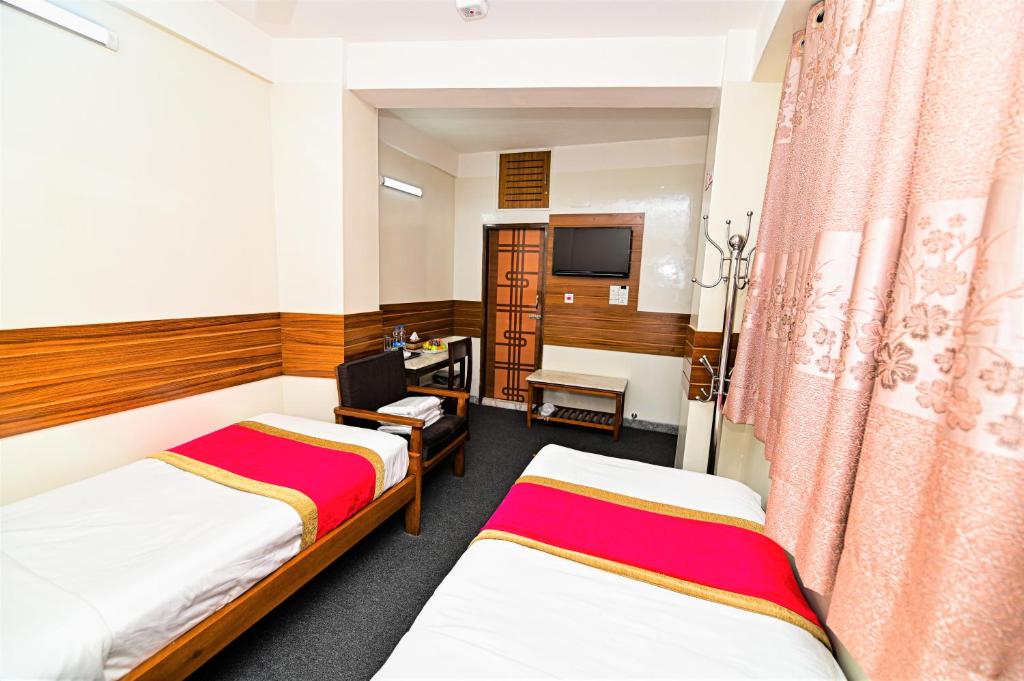 达卡The Shahin Residence的一间酒店客房,设有两张床和电视