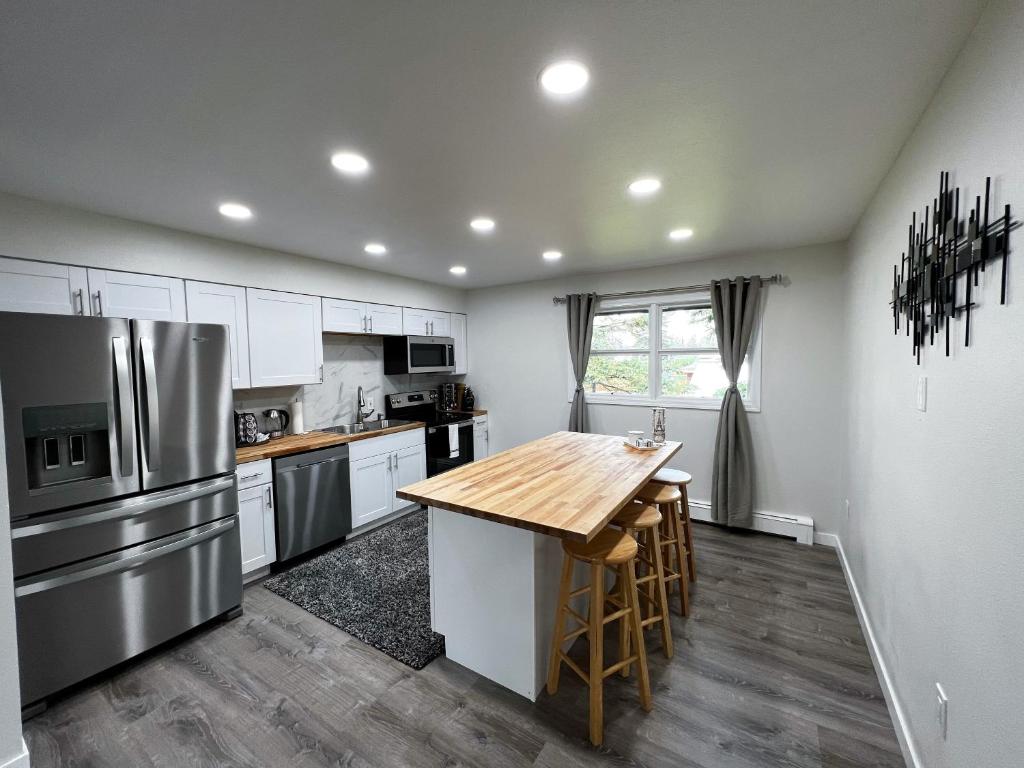 安克雷奇Anchorage midtown apartment-Wyoming 2的厨房配有白色橱柜和木桌