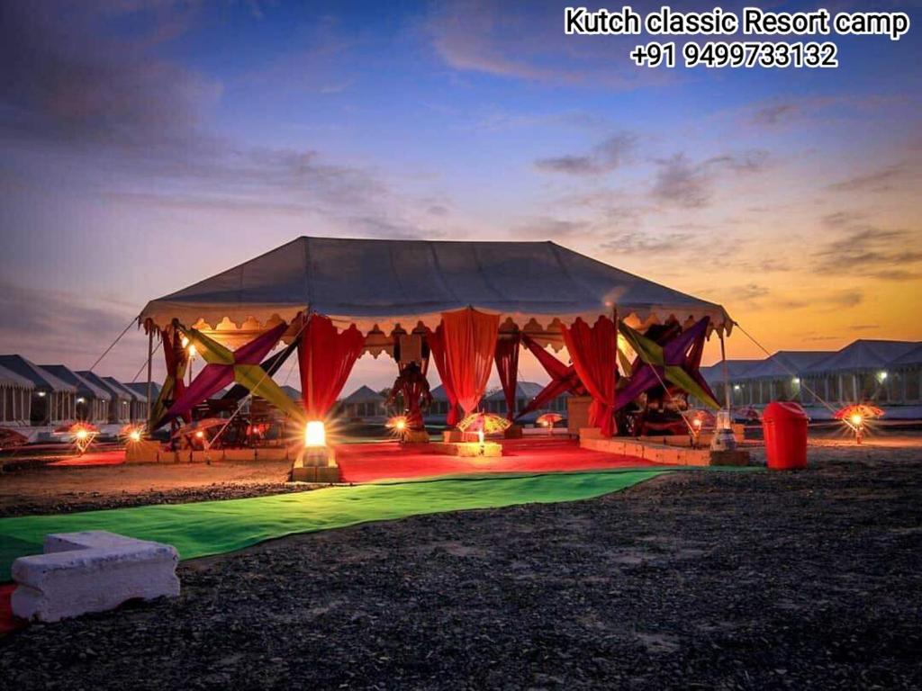 DhordoKutch Classic Resort Camp的田野中带红色和绿色照明的帐篷
