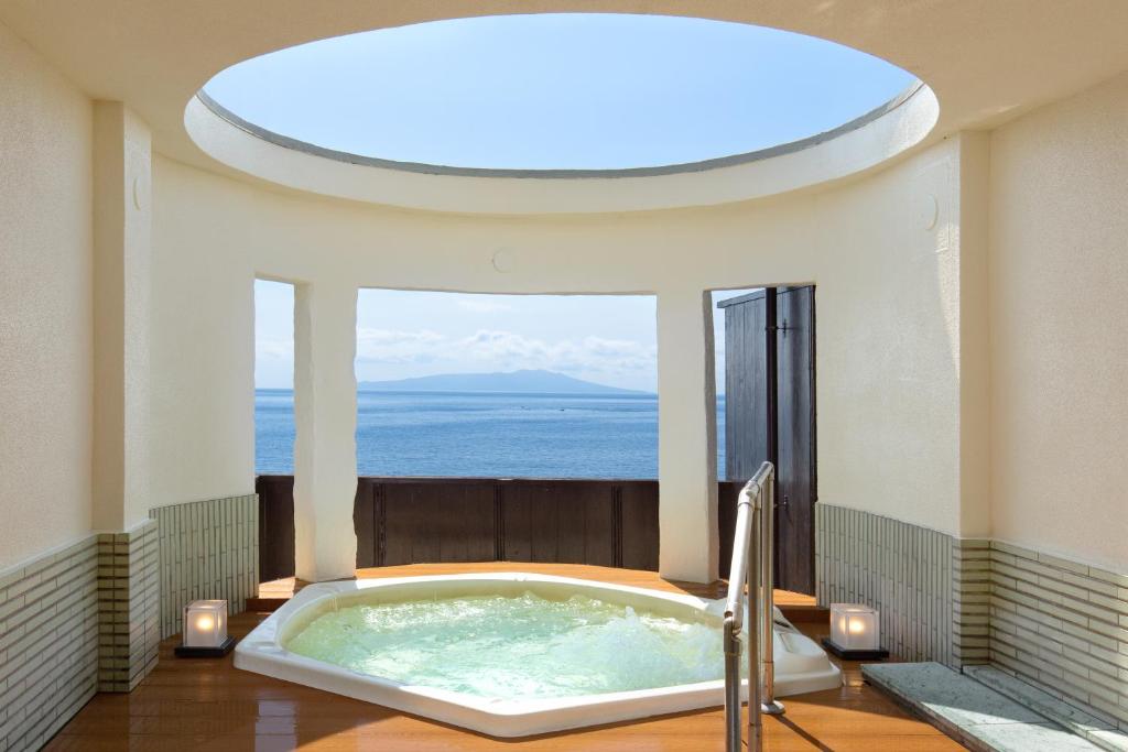 东伊豆町吉祥亭日式旅馆的窗户客房内的大浴缸