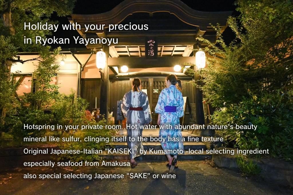 植木町Ryokan Yayanoyu的两个人晚上站在房子前面
