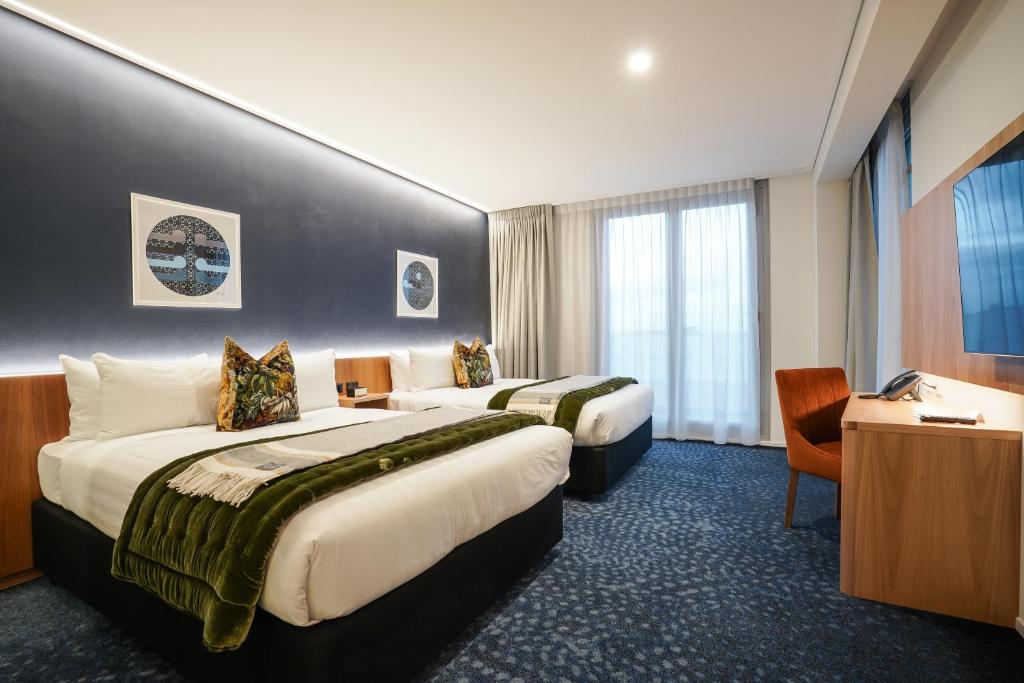 因弗卡吉尔The Langlands Hotel的酒店客房配有两张床和一张书桌