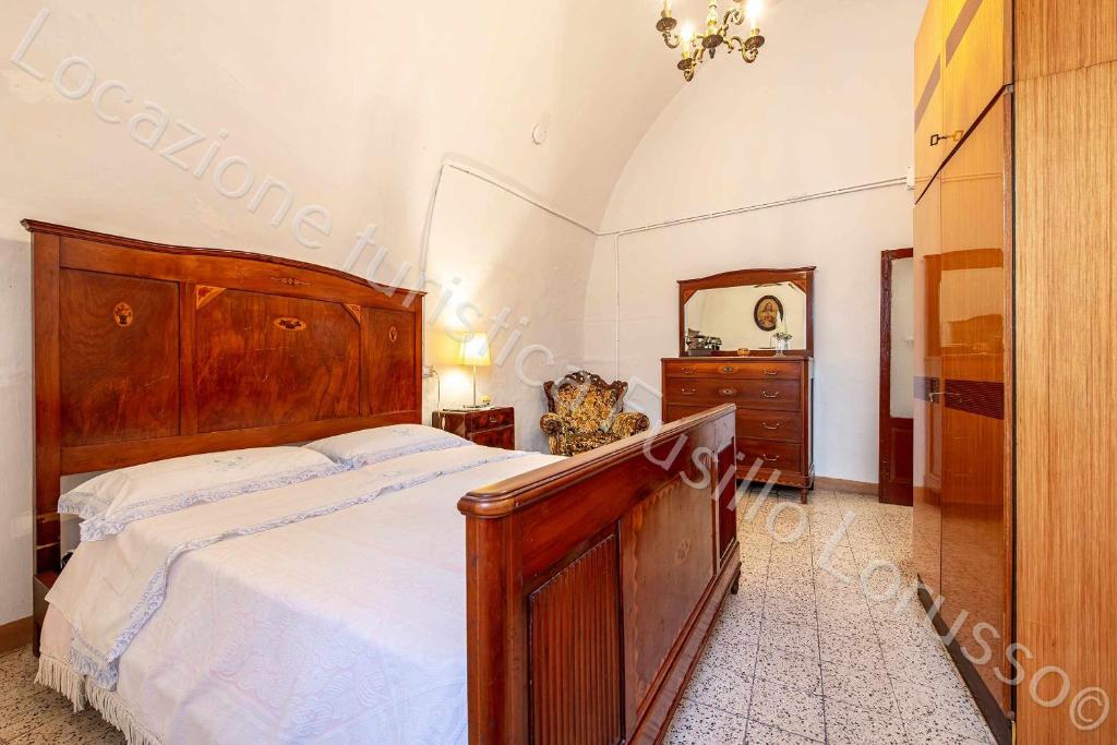 安德里亚Locazione turistica Lorusso 1的一间卧室配有一张大木床和镜子