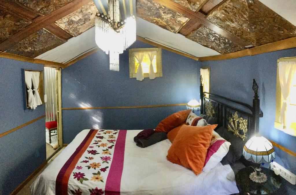 RensburgdorpThe shack life的一间卧室配有一张带蓝色墙壁和吊灯的床。