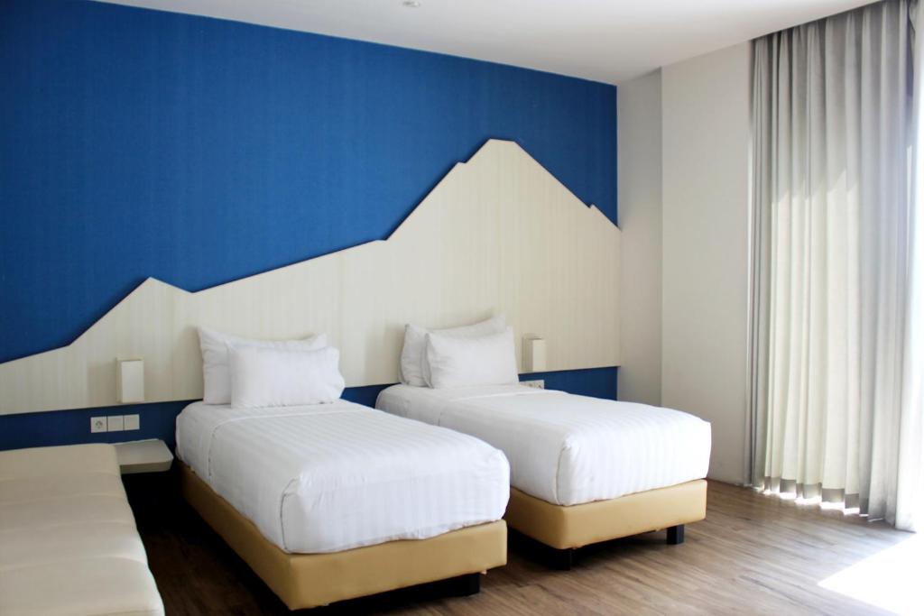庞越庞越布鲁姆公园酒店 的配有2张床的蓝色和白色墙壁客房