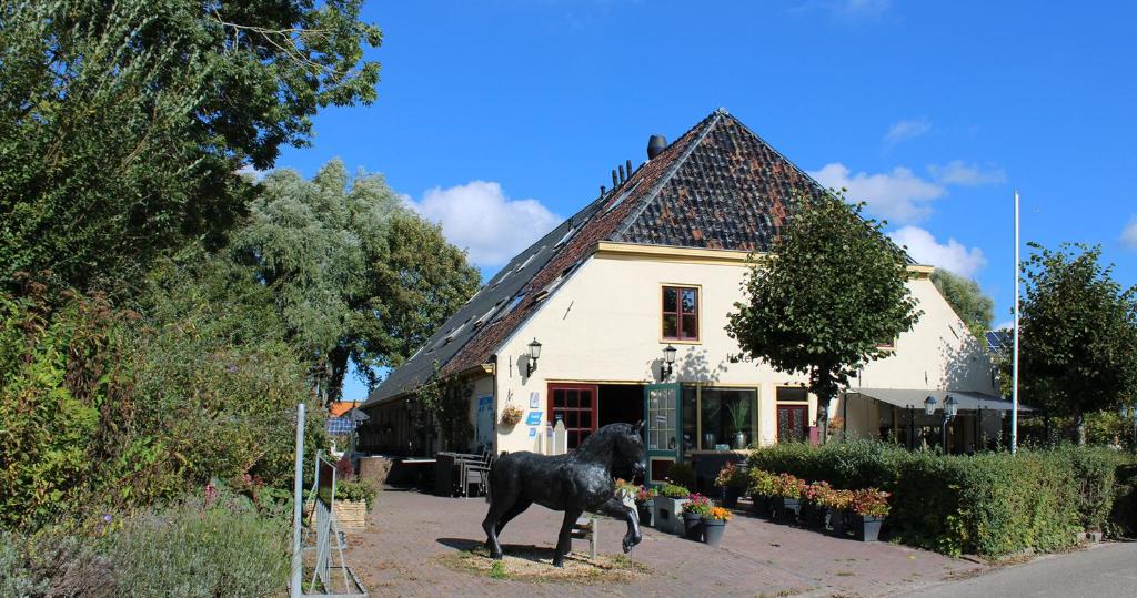 WesternielandDe Oude Smidse的黑狗在房子前的雕像