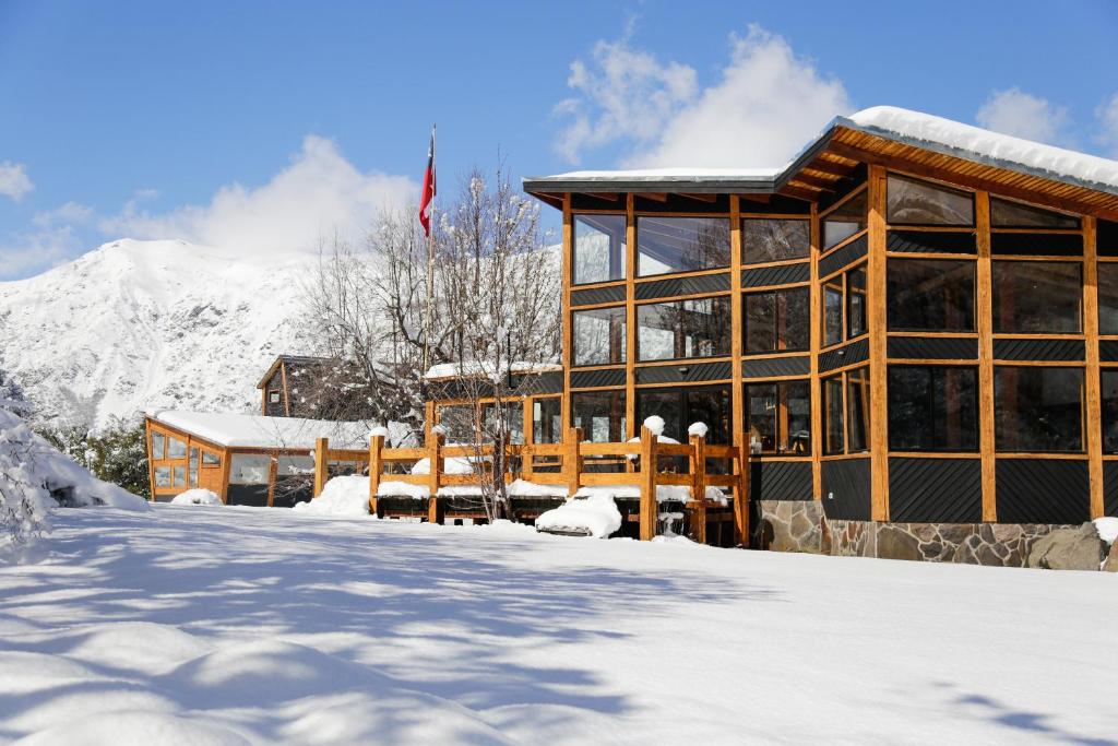 拉斯特朗卡斯MI Lodge Las Trancas Hotel & Spa的一座雪中与山间的建筑