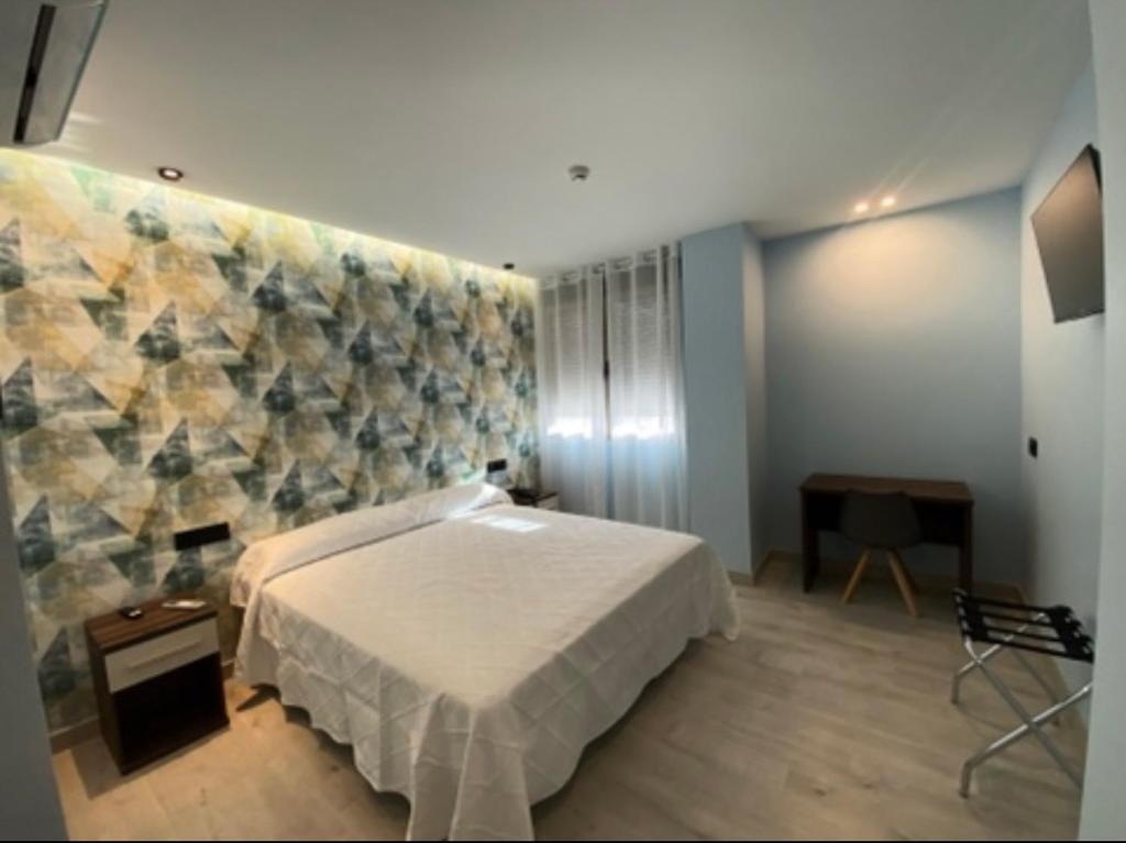 AbaránAureo Alojamiento Urbano的一间卧室设有一张床和一面墙