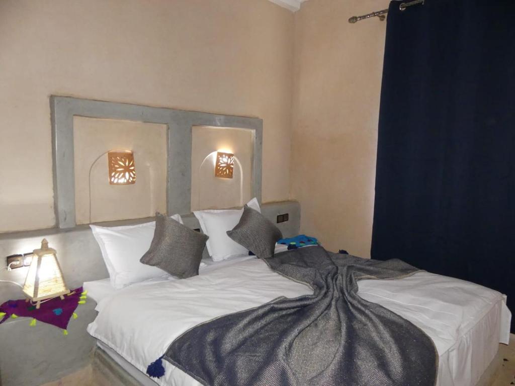 拉希迪耶Dar Diafa Chez Anaam的卧室配有一张带白色床单和枕头的大床。