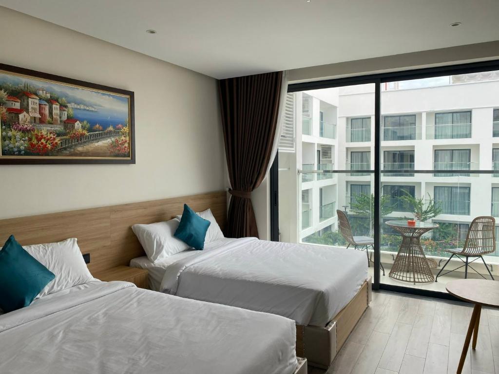 绥和市IVORY Apartment Apec Phu Yen with POOL Access的酒店客房设有两张床和一个阳台。