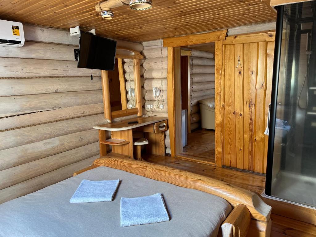 TeterivkaGostynna sadyba Kit Bayun的小木屋内的卧室配有1张床和电视