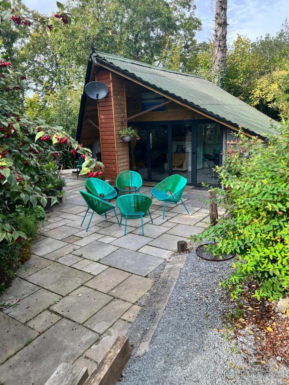 斯旺西The Shed . A cosy, peaceful, 96% recycled, chalet.的一个带绿色椅子的庭院和一座建筑