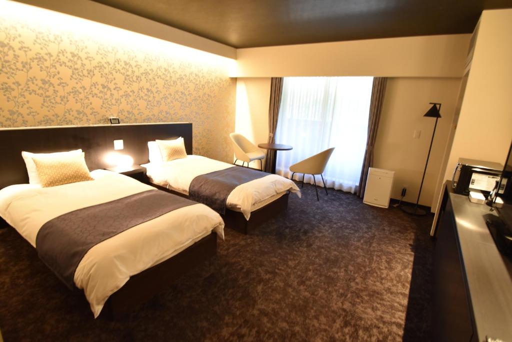 ShimmachidōriK-style gosyonishi的酒店客房设有两张床和窗户。