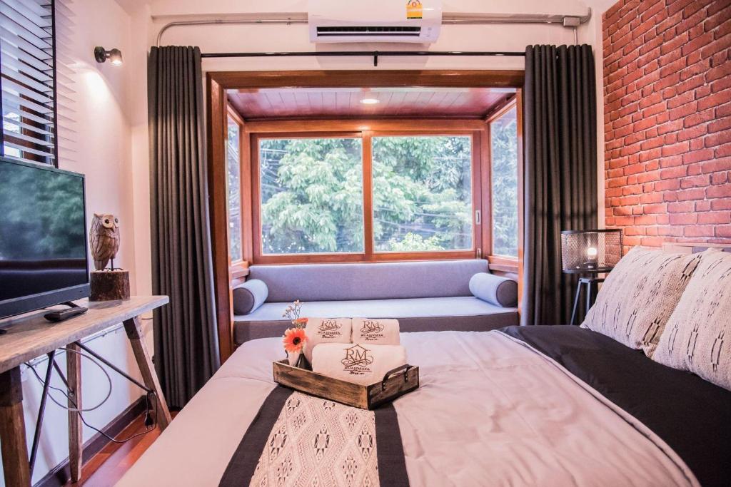清迈Ruanmata Homestay的一间卧室设有一张床和一个大窗户