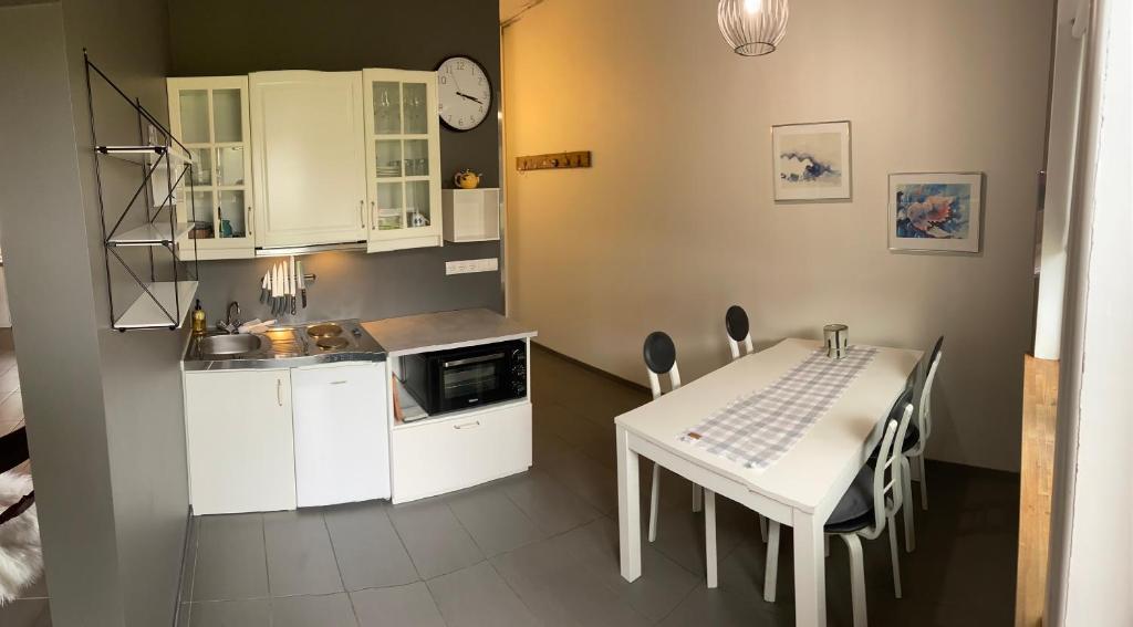 惠拉盖尔济Mörk Guesthouse的厨房配有白色橱柜和桌椅