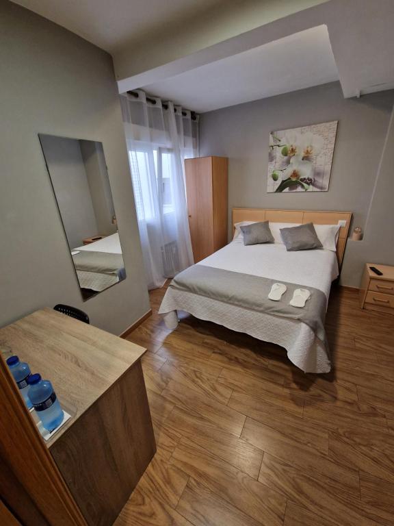 奥维多菲达尔戈旅馆的一间卧室配有一张大床和镜子