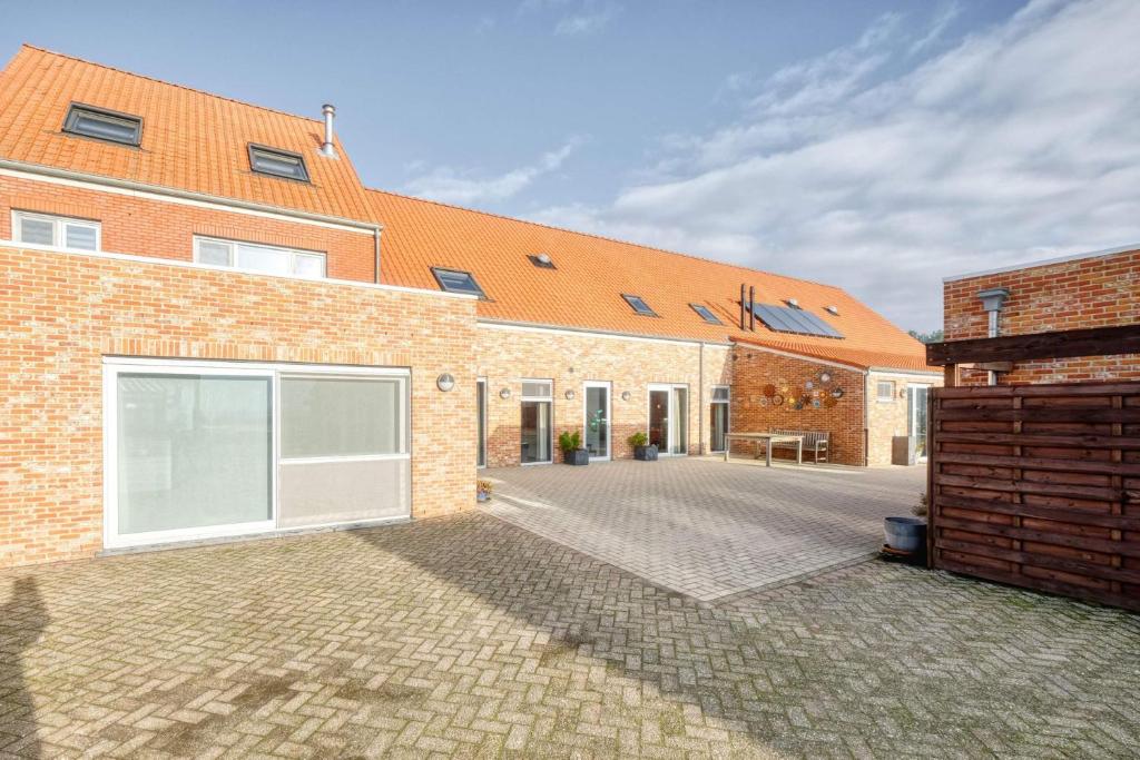 VlimmerenHoeve Megusta的一座砖房,拥有橙色的屋顶和庭院