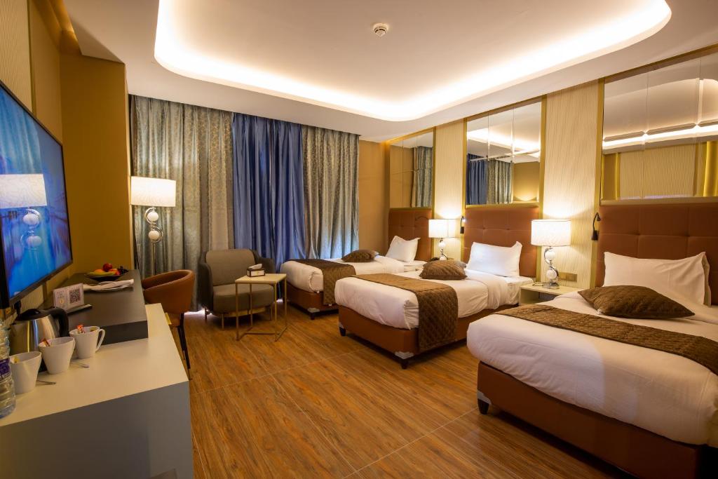 瓦迪穆萨Petra Moon Luxury Hotel的酒店客房配有两张床和一张书桌