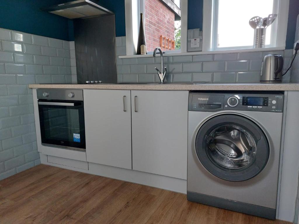 Kentspacious self-contained accommodation 135 cantebury road的厨房配有洗衣机和水槽