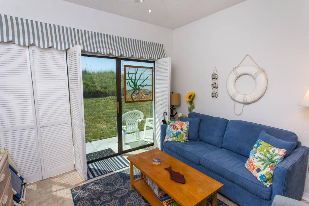 沃尔顿堡滩Bayou Dwellers Cabana Colony #6的客厅配有蓝色的沙发和桌子