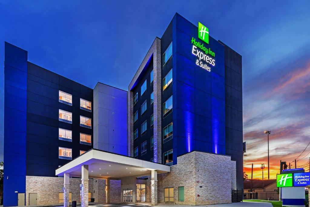 休斯顿Holiday Inn Express & Suites - Houston - N Downtown, an IHG Hotel的上面有灯的标志的酒店大楼