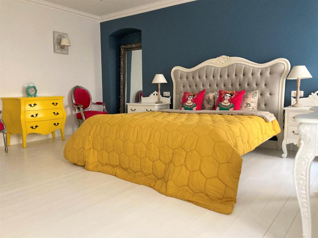 维尔纽斯Shabby Chic - apartment in the Heart of Vilnius Old Town的一间卧室配有黄色的床和红色枕头