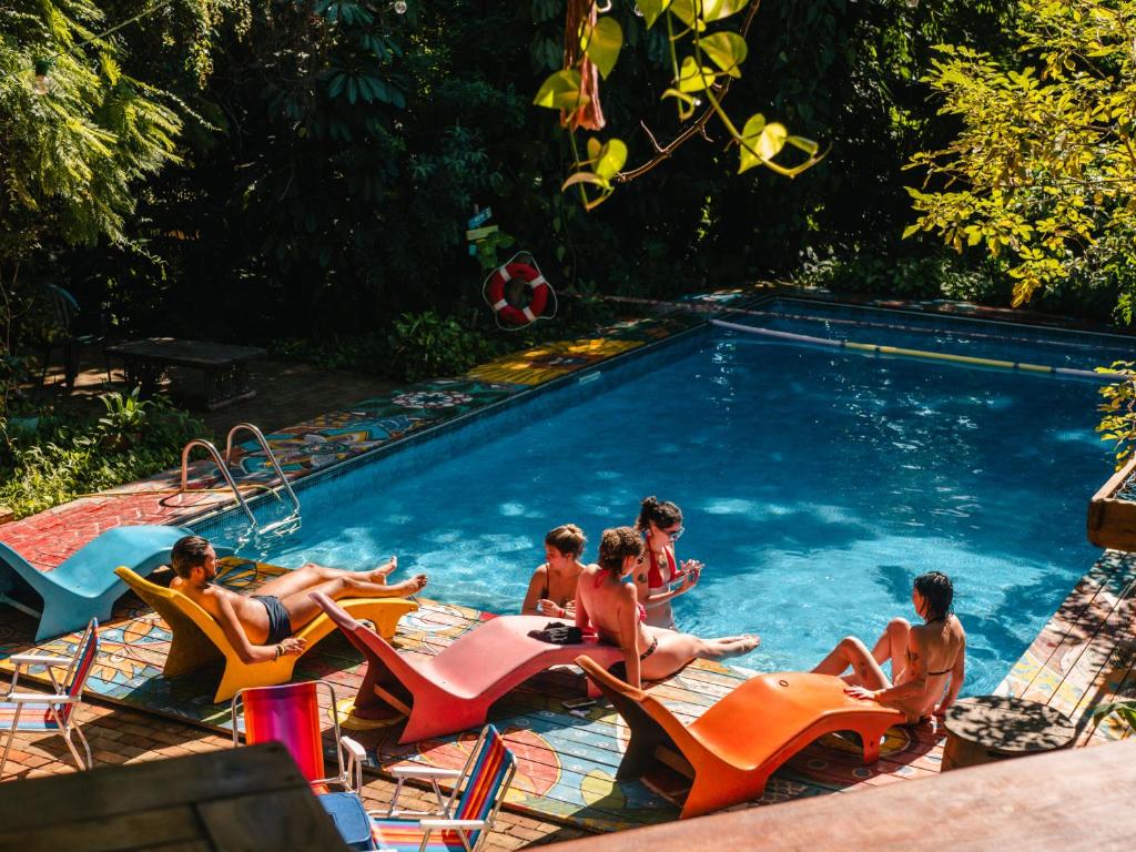 伊利亚贝拉Hostel Da Vila Ilhabela的一群人坐在游泳池里