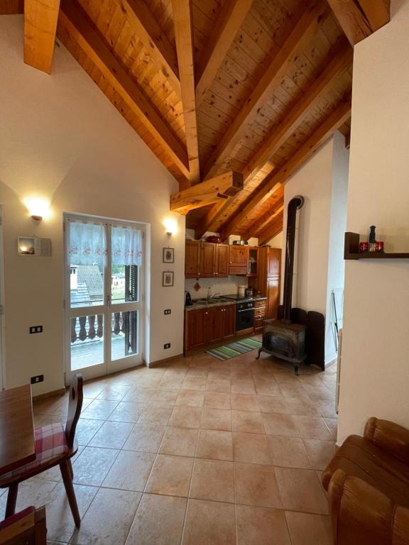 Ceppo MorelliAttico sul Rosa的一间带木制天花板的大客厅和厨房