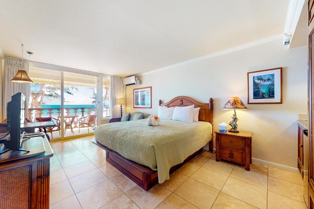 卡帕阿Islander on the Beach 353的一间卧室配有一张床、一台电视和一个阳台