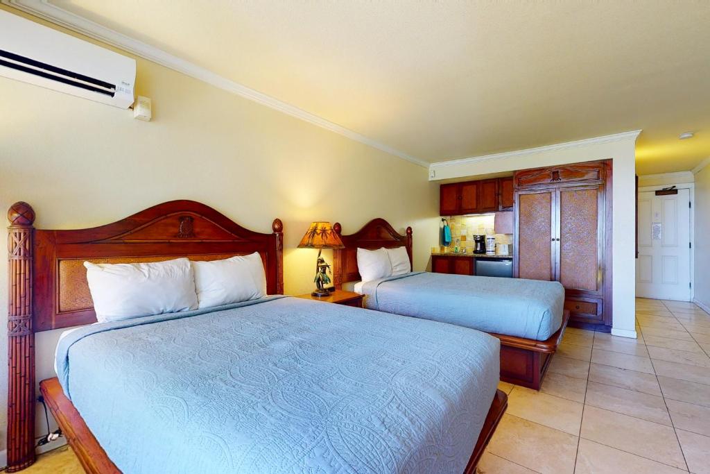 卡帕阿Islander on the Beach 211的一间带两张床的卧室和一间厨房