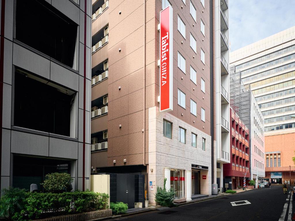 东京Tabist Ginza的一面有红色标志的建筑物