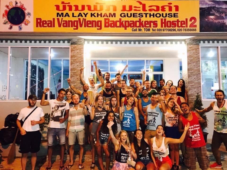 万荣Vang Vieng Freedom View Hostel的一群人站在一座建筑物前摆着一张照片