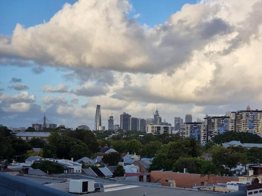 悉尼Lovely 2 bedroom apartment with city views的城市景观,建筑和云层