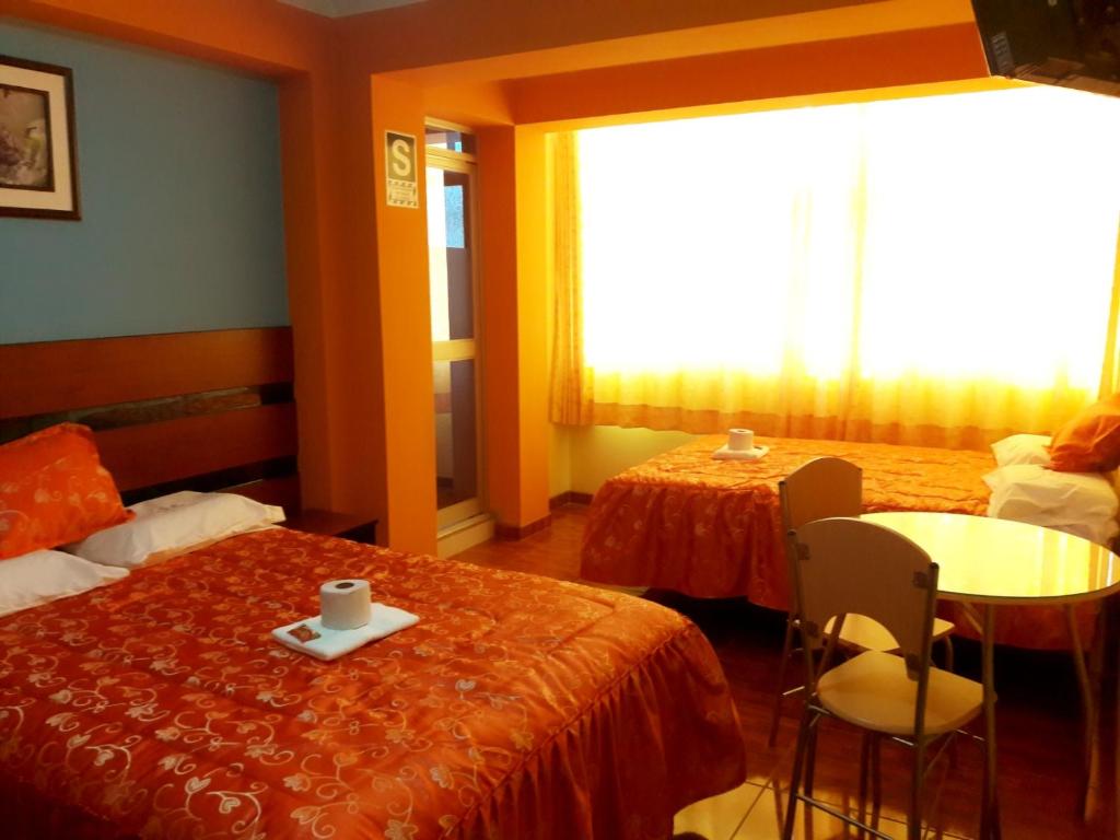塔克纳Tesoro Suite的酒店客房带两张床和一张桌子以及椅子。