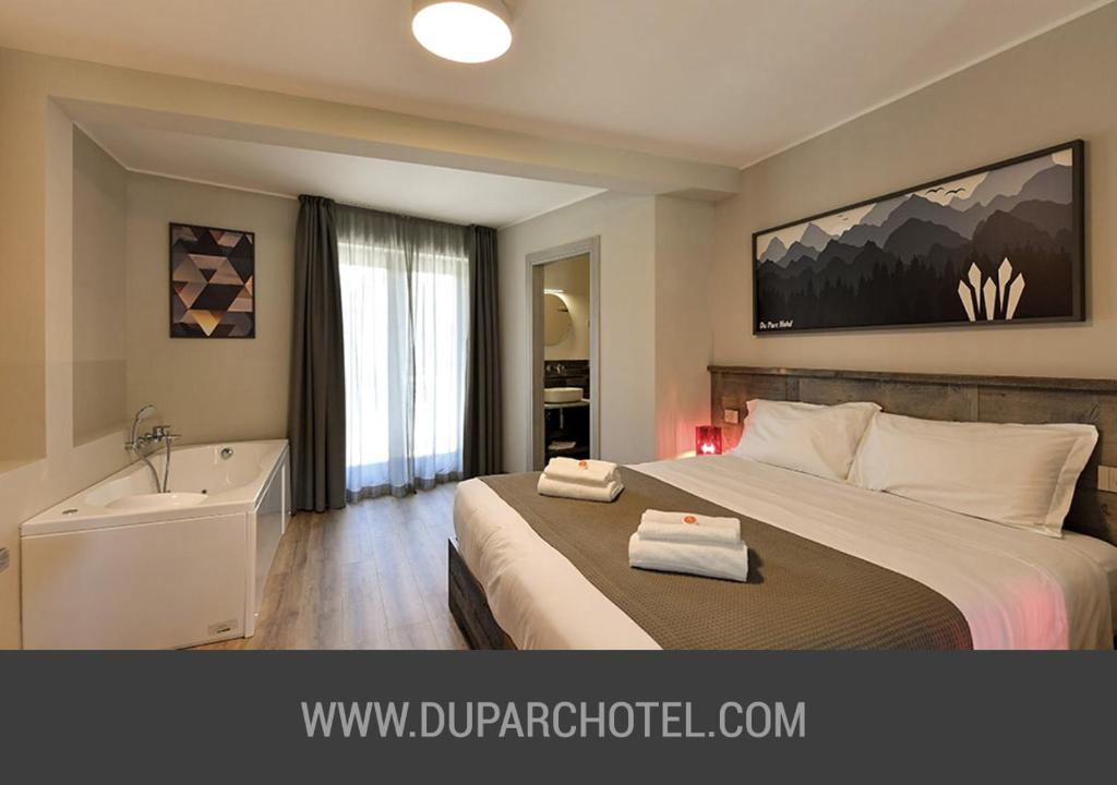 萨奥兹-杜尔克斯Du Parc Hotel的一间卧室配有一张床、一个浴缸和一个水槽