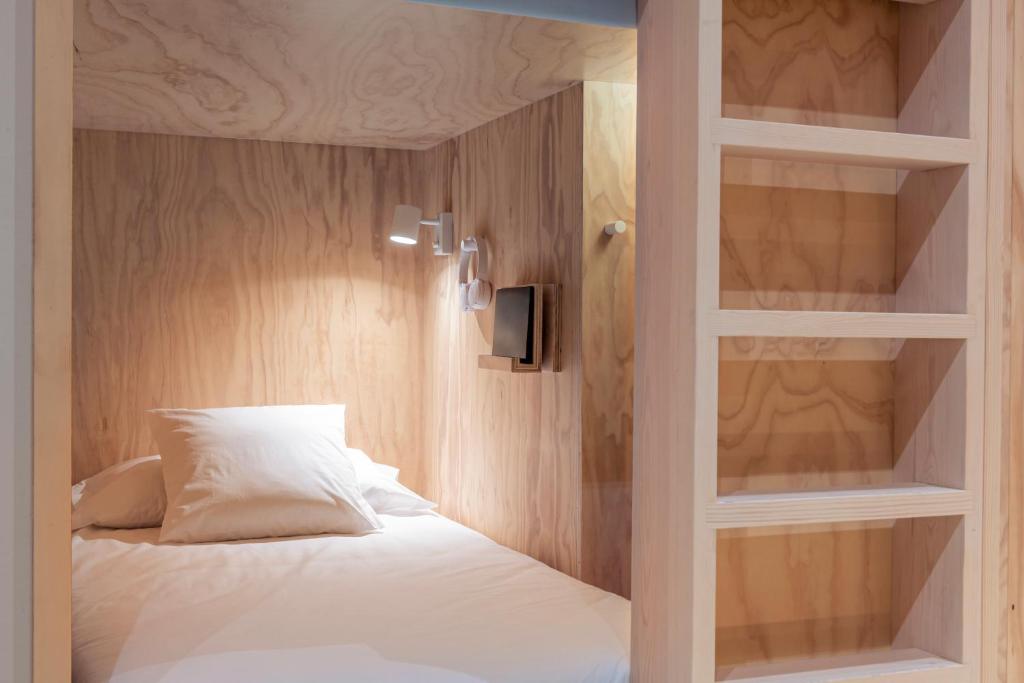 圣塞瓦斯蒂安Colo Colo Hostel - Single Private Beds的一间卧室配有一张带内置书架的床