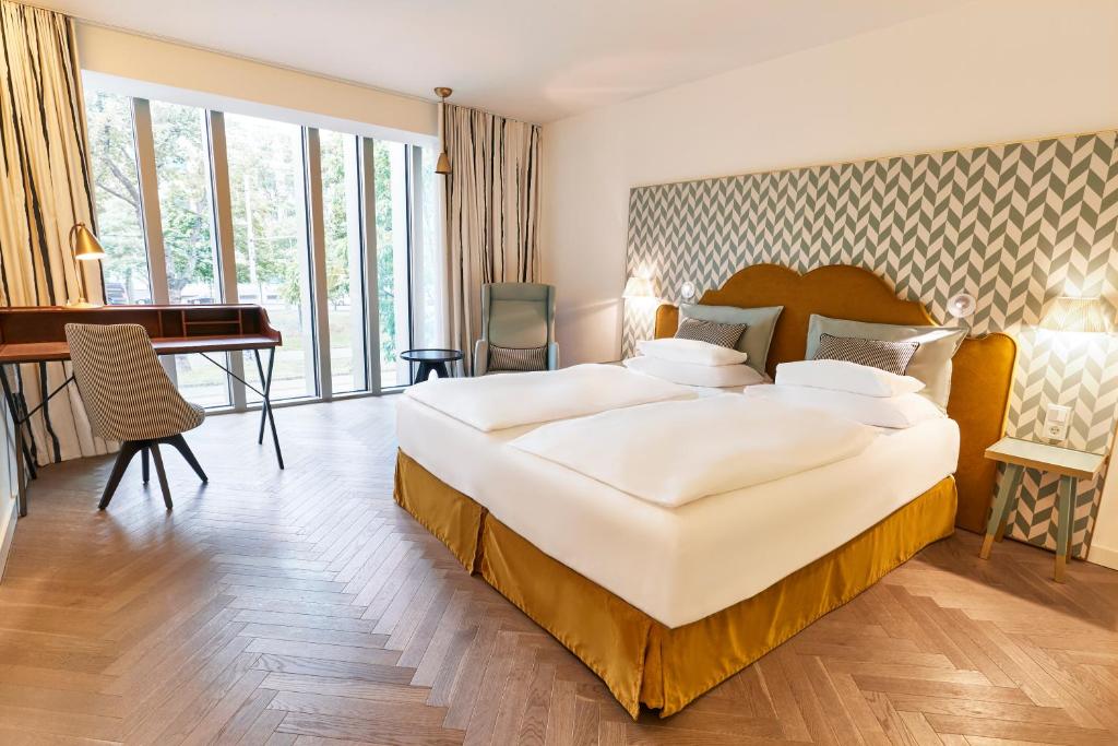 维也纳MAXX by Steigenberger Vienna的酒店客房设有一张大床和一张书桌。