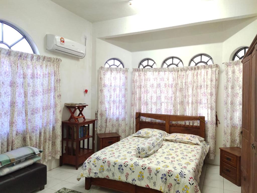 怡保Homestay YatiMizi (Bungalow Station 18, Ipoh)的一间卧室配有床和带窗帘的窗户
