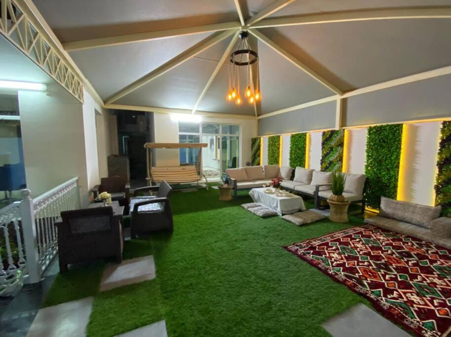 MawāliḩAl Aryam Villa的带沙发和绿色地毯的客厅