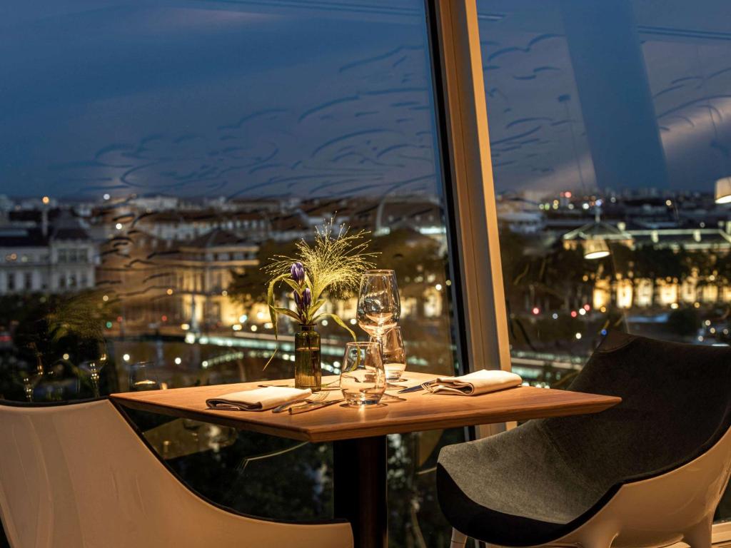 里昂索菲特里昂贝勒库尔酒店的一张晚上享有城市美景的桌子