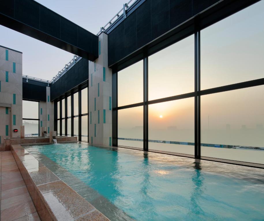 熊本Candeo Hotels Kumamoto Shinshigai的一座带大窗户的建筑内的游泳池