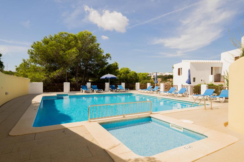 卡拉莫若尔萨考尼公寓式酒店的一个带蓝色躺椅的游泳池和一个游泳池