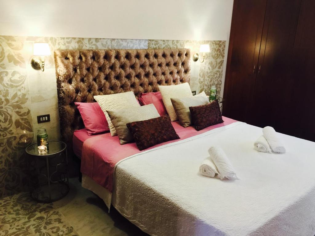 拉拉古纳Il Sogno di Gio della Laguna的一间卧室配有两张带白色和粉色枕头的床