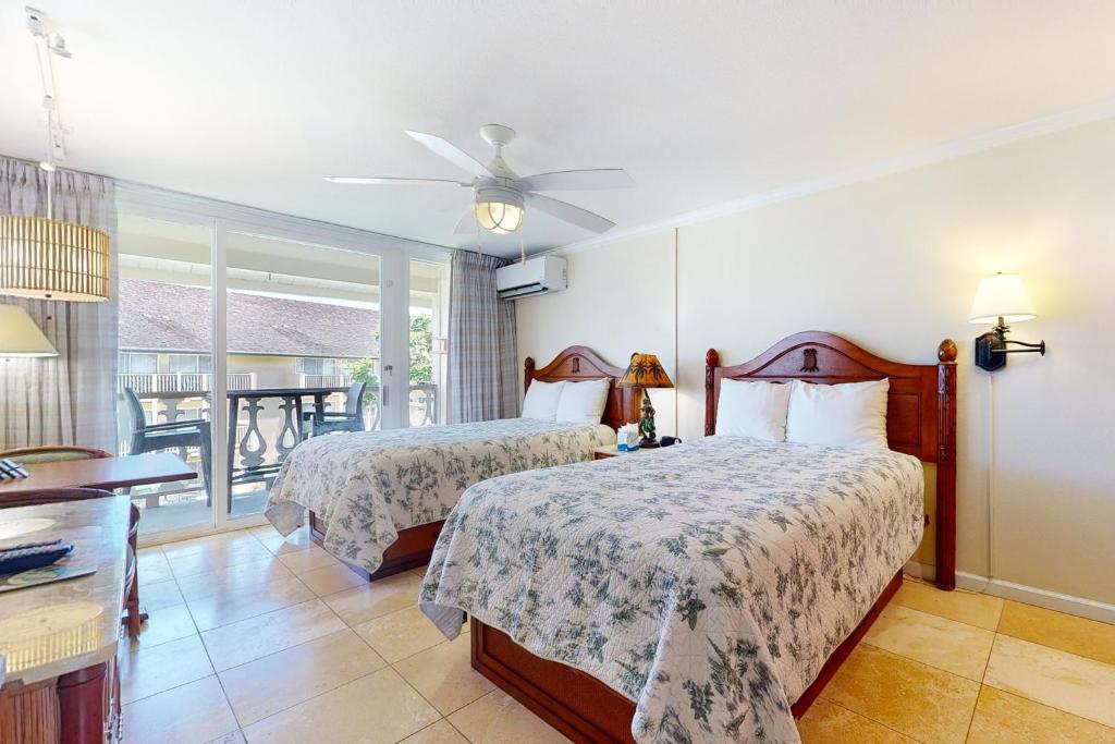 卡帕阿Islander on the Beach 315的一间带两张床的卧室和一个阳台