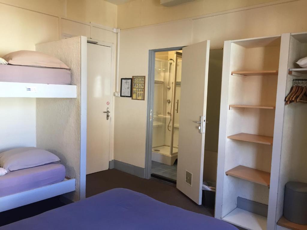 勒图凯-巴黎普拉日AUBERGE RIVA BELLA的客房设有两张双层床和步入式淋浴间。
