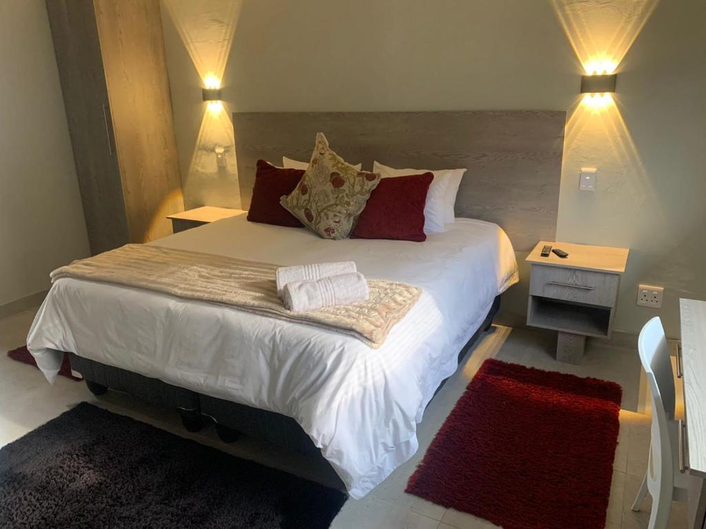 昆斯敦Conti-INN Guesthouse的一间卧室配有一张带红色枕头的大床