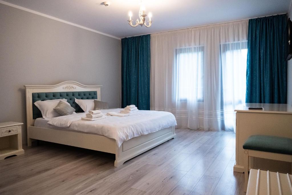 Grădiştea de MuntePerla Dacilor的卧室配有白色的床和蓝色窗帘